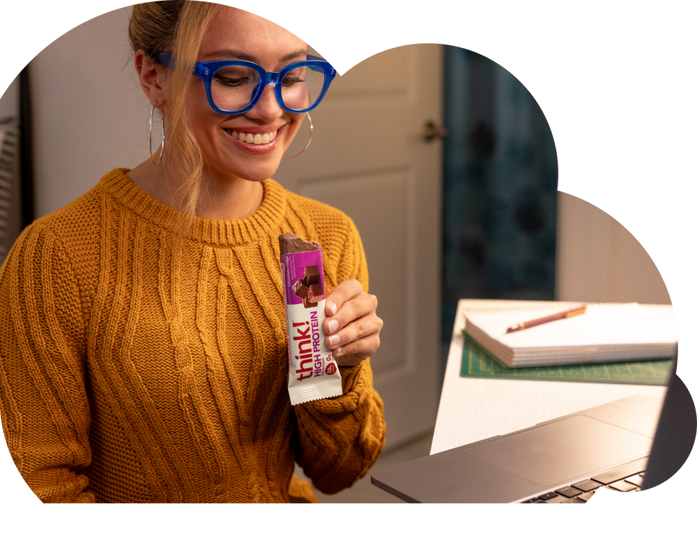 Woman with think protein bar at desk