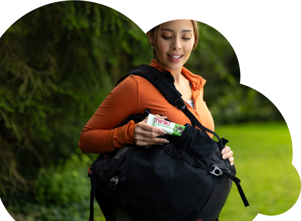 Woman with think protein bar at the park