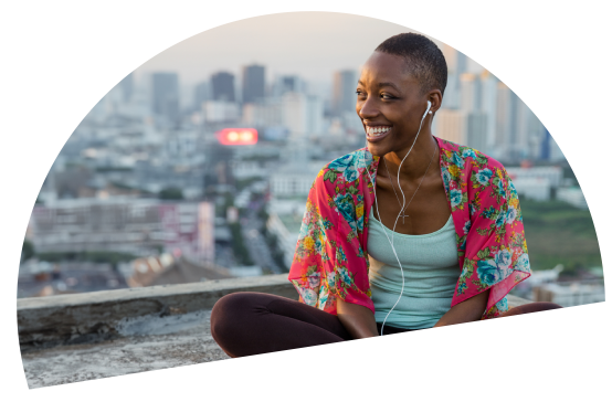 woman listening to music on her headphone outside smiling