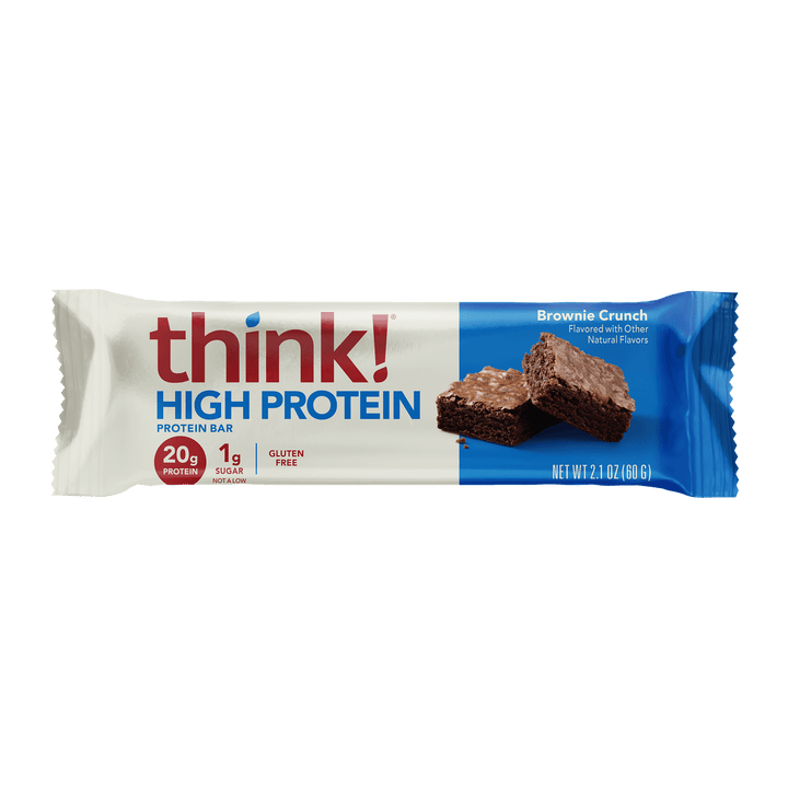 Packaging of a "think! High Protein" bar, with "Brownie Crunch" flavor. White wrapper, blue accents, showing a brownie image. Bold, nutritious vibe.