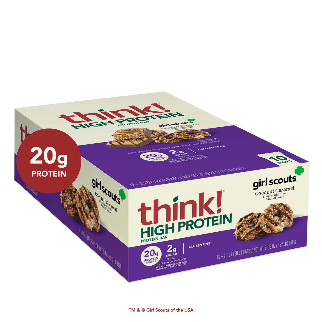 Box of think! High Protein Bars, Girl Scouts Coconut Caramel flavor. Packaging highlights 20g protein, 2g sugar, gluten-free. Box depicts cookies.