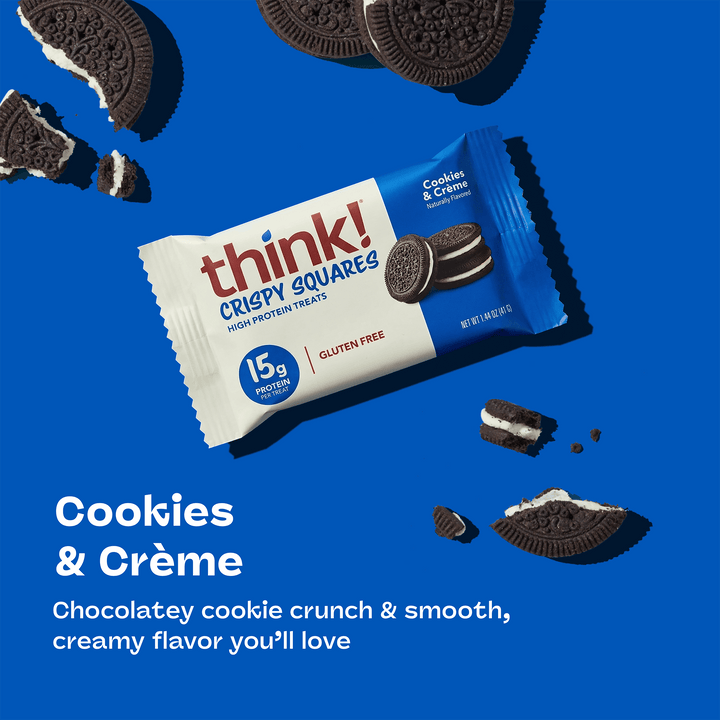 A think! Crispy Squares Cookies & Crème bar on a blue background. Surrounding it are broken chocolate cookies with cream filling, conveying indulgence.